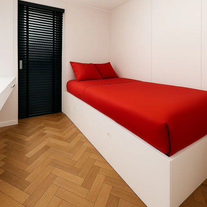 Slaapkamer met rood bed in de Buitenkamer Kiefern modulaire woning